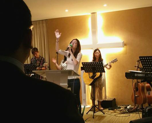 You Qian leading worship during service